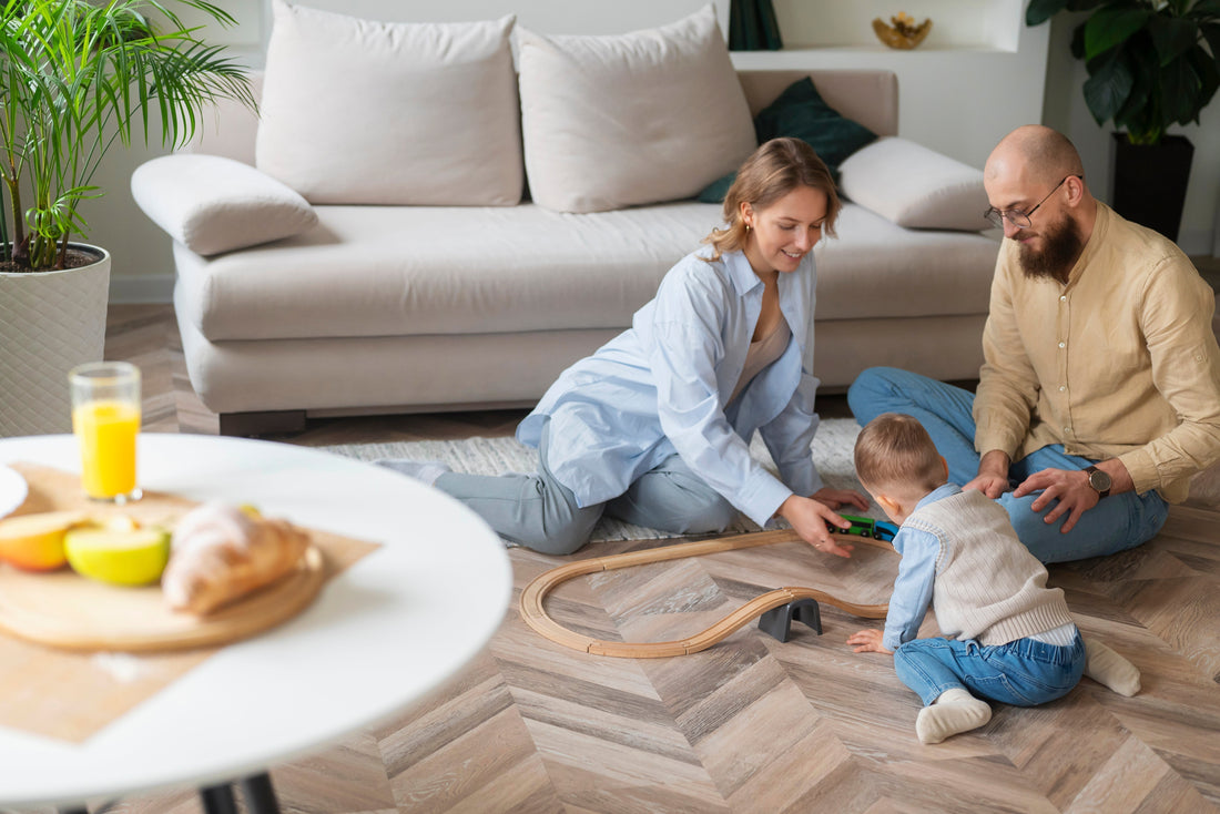 A happy family playing on their living room floor, showcasing beautiful hardwood installed by flooring contractors in Colorado Springs.