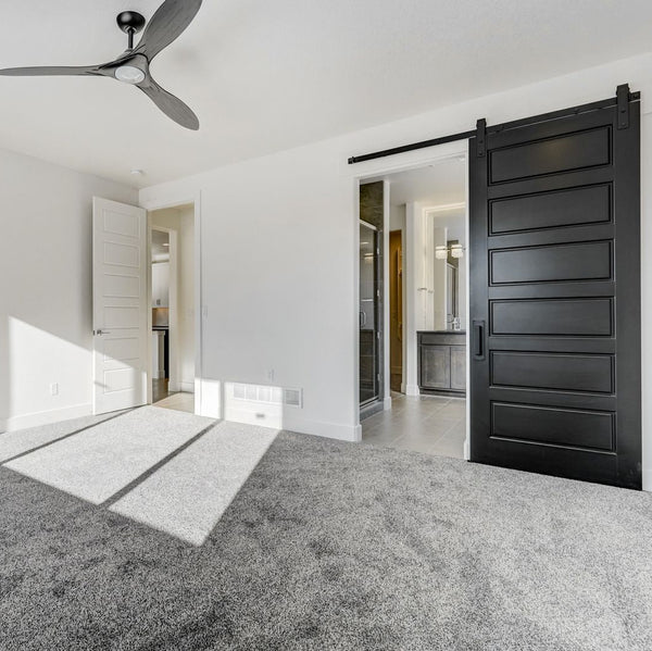 Modern interior with a black sliding door, gray carpet, and white walls.