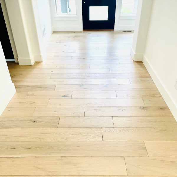 Wooden floor in a room with white walls and a blue door.