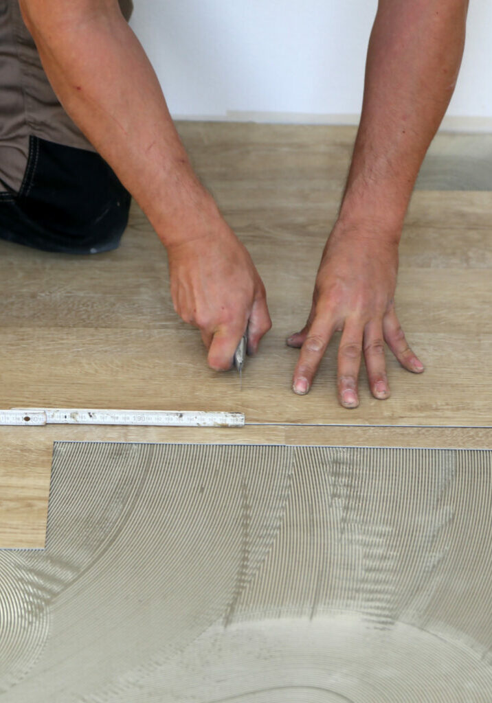 Work on laying flooring. Worker installing new vinyl tile floor | Floor Craft